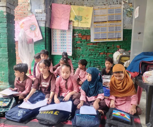 शहर में कबूलपुरा स्थिति प्राथमिक विद्यालय में ज़मीन पर बैठे बच्चे। जागरण